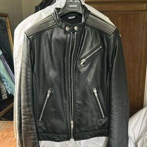 MOSCHINO men’s black leather motorcycle jacket with zipper detail.